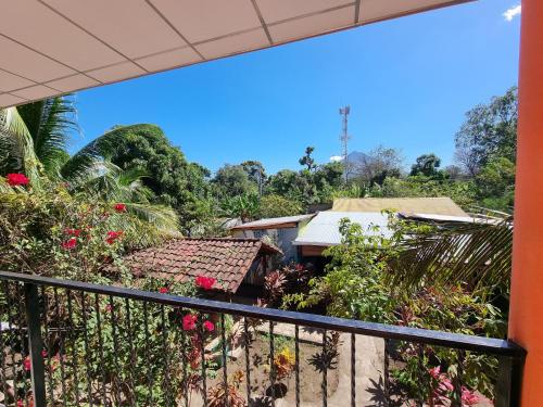 a balcony view of a house with flowers at Ometepe House in Moyogalpa
