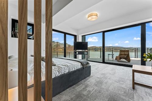 a bedroom with a large bed and large windows at NOI Resort SPA - woda i las in Tęgoborze