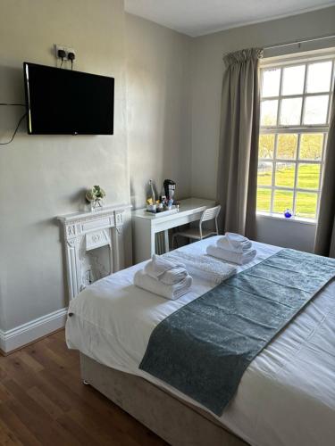 a bedroom with a bed with towels on it at The Old Postie Bed & Breakfast in Annesley