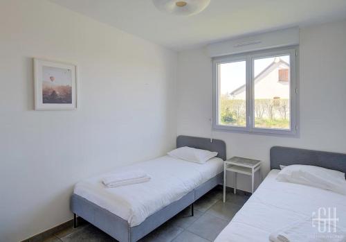 2 camas en una habitación con ventana en La Choisille / Maison 3 chambres en Cerelles