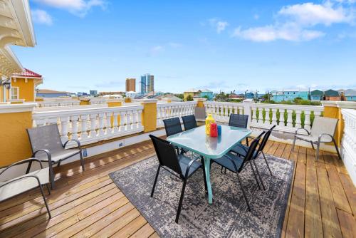 a patio with a table and chairs on a balcony at Summer Special, Lux 4BR House Sleeps 12, Pool, Elevator, King bed in Panama City Beach