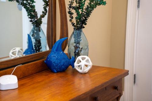 a table with three blue vases and a mirror at Summer Special, Lux 4BR House Sleeps 12, Pool, Elevator, King bed in Panama City Beach