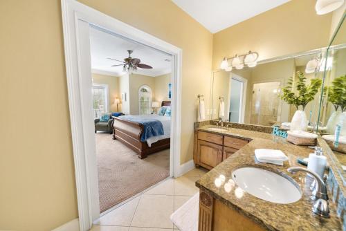 a bathroom with a sink and a bedroom with a bed at Summer Special, Lux 4BR House Sleeps 12, Pool, Elevator, King bed in Panama City Beach