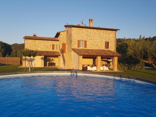 uma casa com uma grande piscina em frente em Agriturismo Villa al piano em Todi