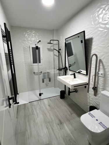a bathroom with a sink and a shower and a mirror at El descanso de la Covatilla in Béjar