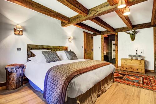 - une chambre avec un grand lit et des plafonds en bois dans l'établissement Résidence La Ferme De Marie - Chalet 