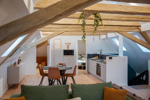 une cuisine et un salon avec une table et des chaises dans l'établissement Le 1552 - Gîte de charme - Parking Gratuit, à Bergheim