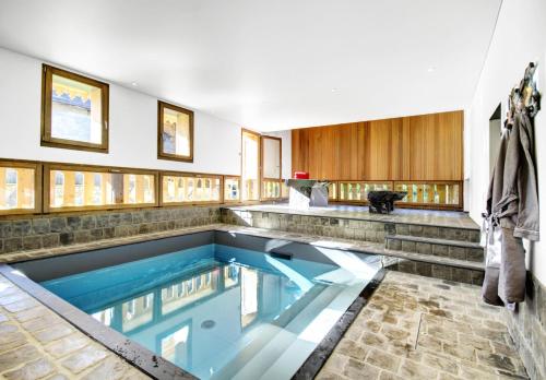 une piscine intérieure d'eau bleue dans une maison dans l'établissement Résidence Villa Solaire - Chalet Villa Solaire - 14 Personnes - Morzine MAE-3761, à Morzine