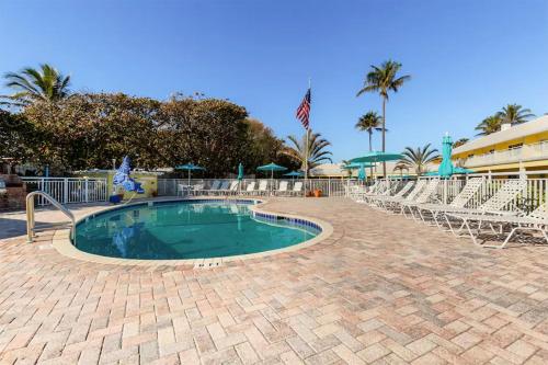 a swimming pool with chairs and an american flag at Berkshire on the Ocean in Delray Beach