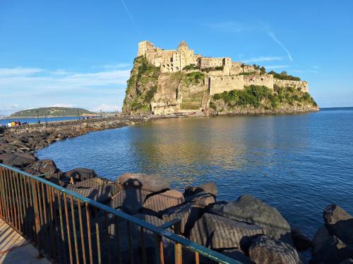 un château au sommet d'une île dans l'eau dans l'établissement GUEST HOME, à Ischia