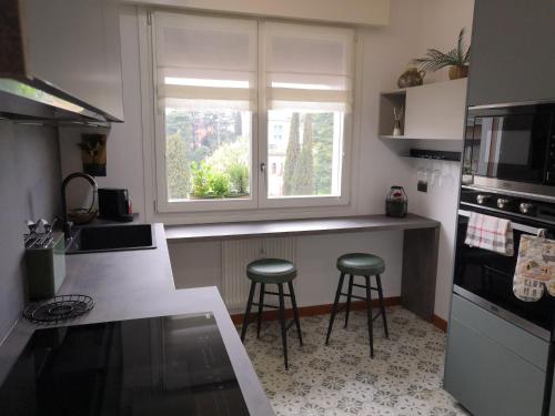 a kitchen with two stools in front of a window at Locazione Lilibet in Conegliano
