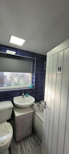 a bathroom with a white toilet and a sink at Rent Entire Calmhaven Apartment in Nottingham