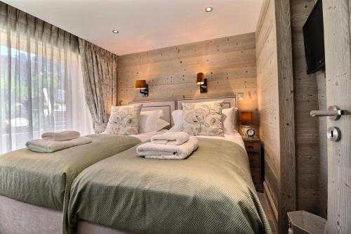 deux lits dans une chambre aux murs en bois dans l'établissement Résidence Explorer Meleze - Chalet Explorer - 14 Personnes - Les Gets MAE-3781, aux Gets