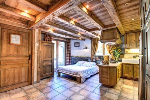 une cuisine avec des plafonds en bois et un lit dans une chambre dans l'établissement Résidence Lolana - Chalet Lolana - 14 Personnes - Morzine MAE-3791, à Morzine