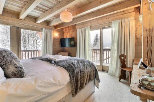 une chambre avec un lit dans une pièce avec des fenêtres dans l'établissement Résidence Explorer Meleze - Chalet Mélèze - 14 Personnes - Les Gets MAE-3801, aux Gets