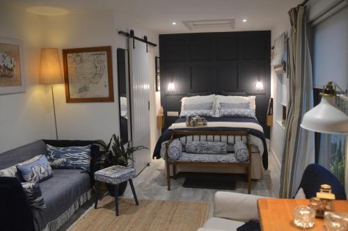 ein Schlafzimmer mit einem großen Bett und einer Couch in der Unterkunft Ropewalk Cottage - A Little Treasure By The Coast in Portaferry