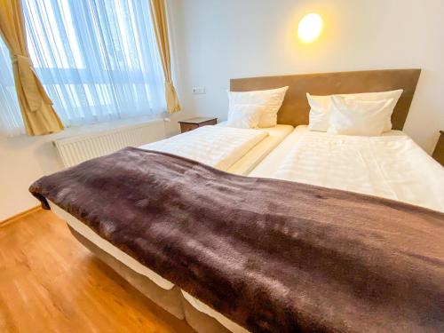 a bedroom with a large bed with a brown blanket at Hotel Waldschlößchen in Mülheim an der Ruhr