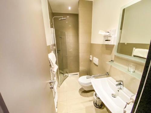 a bathroom with a toilet and a sink at Hotel Waldschlößchen in Mülheim an der Ruhr