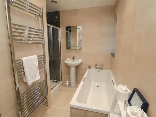 un bagno con doccia, vasca e lavandino di Bothy Cottage ad Alnwick