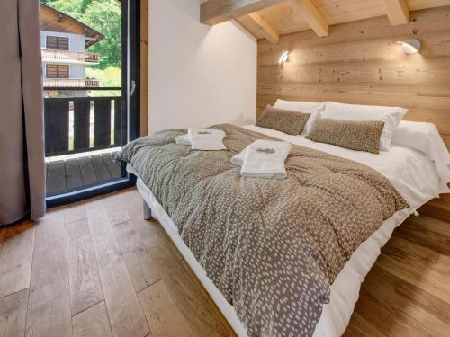 une chambre avec un grand lit avec deux serviettes dessus dans l'établissement Résidence La Moutelette - Chalet La Moutelette - 14 Personnes - Montriond MAE-3831, à Montriond