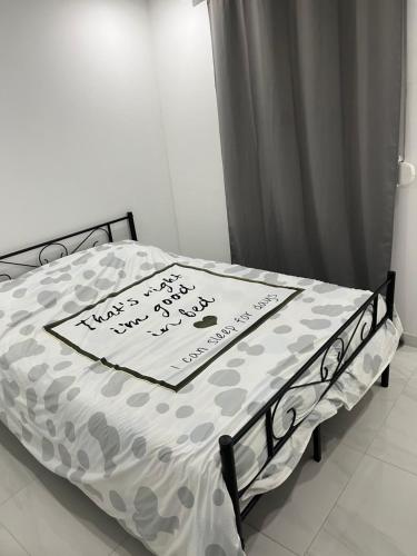 een bed met een laken met een bord erop bij Appartement calme dans villa individuelle in Bagnols-sur-Cèze