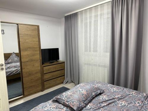 una camera con un letto e un comò con una televisione di Apartament de închiriat a Câmpulung Moldovenesc