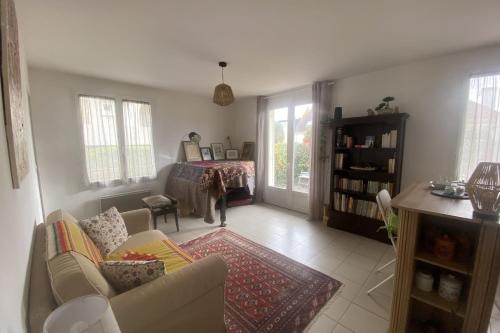 ein Wohnzimmer mit einem Sofa und einem Tisch in der Unterkunft Charming house close to the beach in Ouistreham