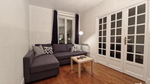 un salon avec un canapé et une table dans l'établissement Beautiful, cosy apartment for 1 to 6 people, located near Olympic Park, à Paris