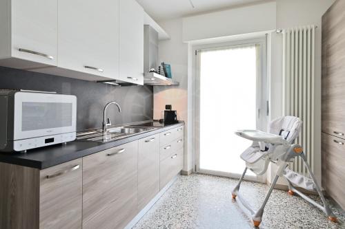a kitchen with a sink and a microwave at Le Lion Apartments - Bike & Ski in Aosta