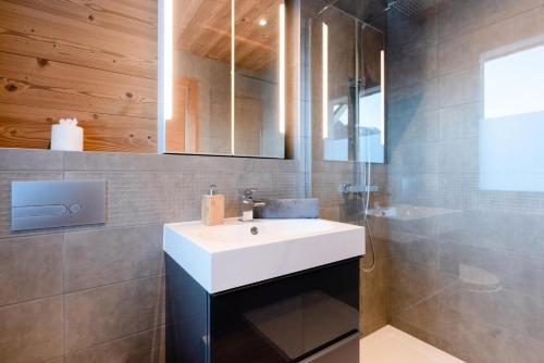 une salle de bain avec un lavabo blanc et un miroir dans l'établissement Résidence Les Rosiers - Chalet Rosiers - 10 Personnes - Montriond MAE-3901, à Montriond