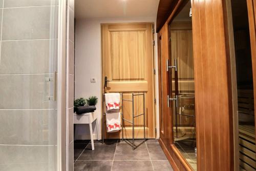 - un couloir avec une porte en bois et une douche à l'italienne dans l'établissement Résidence Kanga - Chalet Kanga - 10 Personnes - Morzine MAE-3921, à Morzine