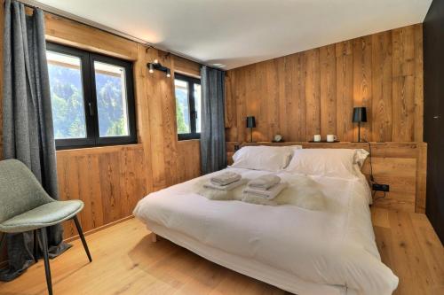 une chambre avec un lit blanc et une chaise dans l'établissement Résidence Fergust - Chalet Fergust - 8 Personnes - Morzine MAE-3941, à Morzine