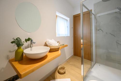a bathroom with a sink and a glass shower at ILLASI DREAM ROOMS in Illasi