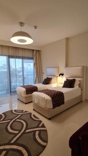 a bedroom with two beds and a rug at Beachfront SeaView Home in Lusail