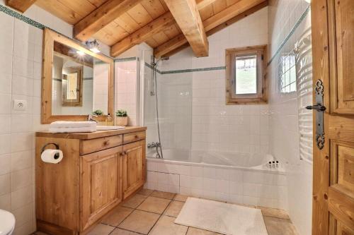 une salle de bain avec une baignoire et un lavabo dans l'établissement Résidence Eveleen - Chalet Eveleen - 8 Personnes - Morzine MAE-3971, à Morzine