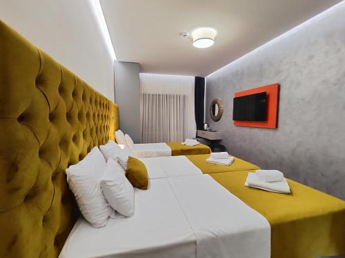 a hotel room with two beds and a television at Lolo Luxury rooms & suites in Budva