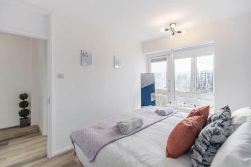 a white bedroom with a bed and a window at Shard view 2BR next Tower Bridge in London