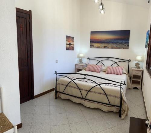 a bedroom with a bed with two pink pillows at Casa mare e relax in Pula