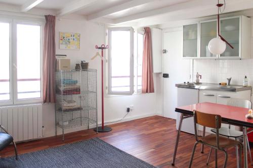 une cuisine avec une table et une cage pour oiseaux dans une pièce dans l'établissement Cosy studio in Paris, à Paris