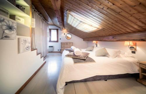 une chambre avec un grand lit avec un plafond en bois dans l'établissement Résidence Morzna - Appartement Morzna - 6 Personnes - Morzine centre MAE-4011, à Morzine