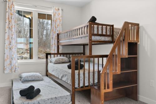 a room with two bunk beds and a staircase at Muskoka Retreat Stunning Hilltop Views in Huntsville