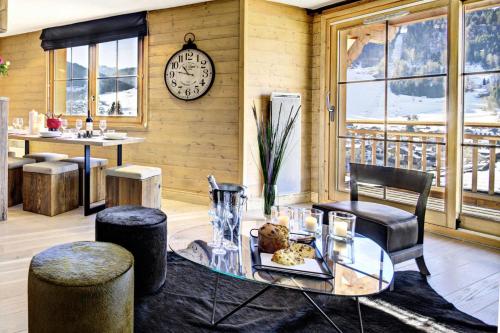 une chambre avec une table, des chaises et une horloge dans l'établissement Résidence Panoramix - Appartement Panoramix - 6 Personnes - Morzine MAE-4041, à Morzine