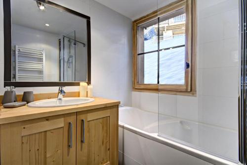 La salle de bains est pourvue d'un lavabo, d'une baignoire et d'une fenêtre. dans l'établissement Résidence Panoramix - Appartement Panoramix - 6 Personnes - Morzine MAE-4041, à Morzine