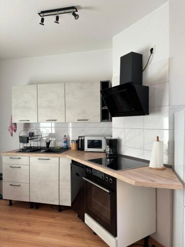 a kitchen with white cabinets and a black stove top oven at Vila Bösdorf Apartments in Calvörde