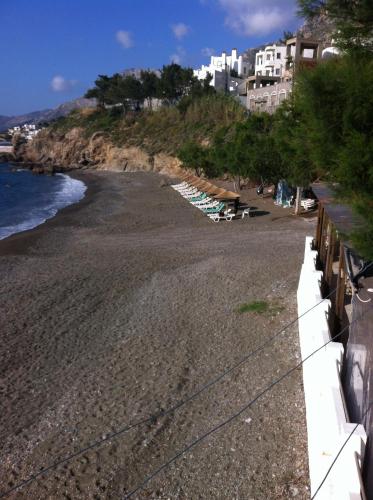 a beach with chaise lounges and buildings at Anna Studios in Myrties