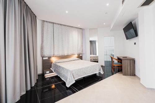 a bedroom with a bed and a window and a desk at Hotel Nuova Grottella in Copertino
