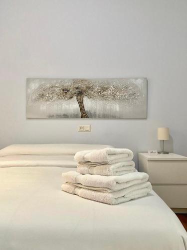 una pila de toallas sentadas encima de una cama en Lemos Estrella, en Monforte de Lemos