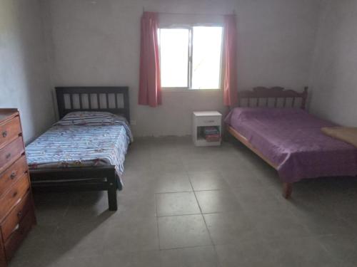 a bedroom with two beds and a dresser and a window at Casa de campo in Vaqueros