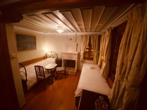 a small room with two beds and a table and a window at Aristotelous Alexandrou Historic Inn in Arnaia
