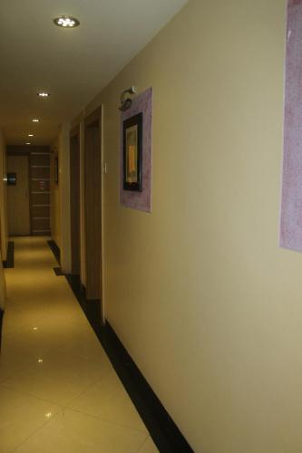 a hallway with a white wall with a picture on it at Hotel Fortune in Mumbai